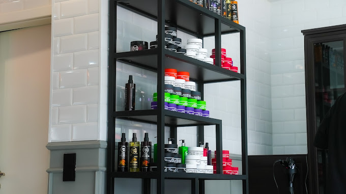 Haarpflege- und Stylingprodukte im Regal beim Barbarossa Barbershop.